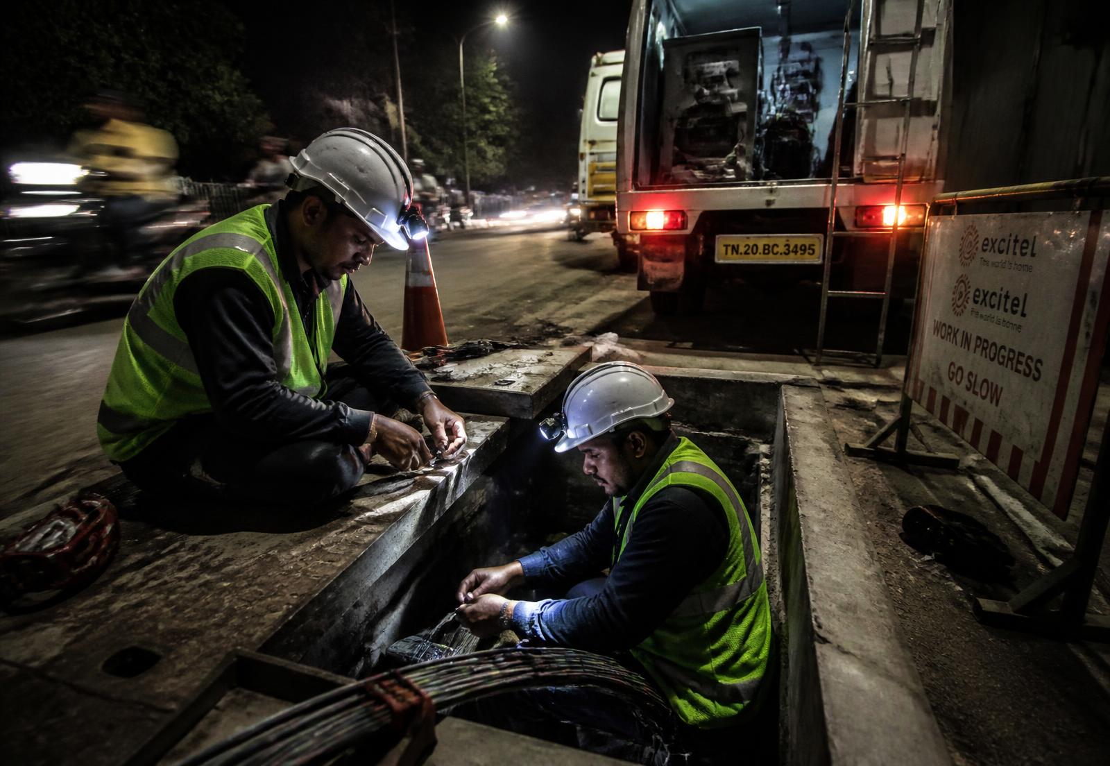 NexGen-style field engineers working on underground fiber at night